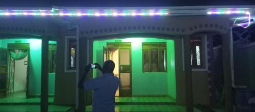 a person taking a picture of a room with green lights at DAR Guest House in Kabarole