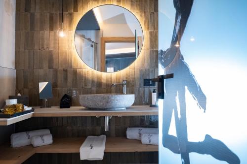 a bathroom with a sink and a mirror at Locanda degli Artisti Art Hotel in Canazei