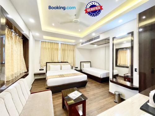 a hotel room with a bed and a couch at Hotel A ONE pride ! Puri fully-air-conditioned-hotel near-sea-beach-&-temple with-lift-and-parking-facility restaurant-availability in Puri