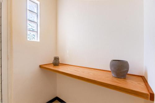 two vases sitting on a wooden shelf in a room at Via Tendenza Condos in Playa del Carmen