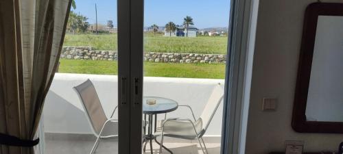 a view of a table and chairs through a sliding glass door at VENOS APARTMENTS in Marmari