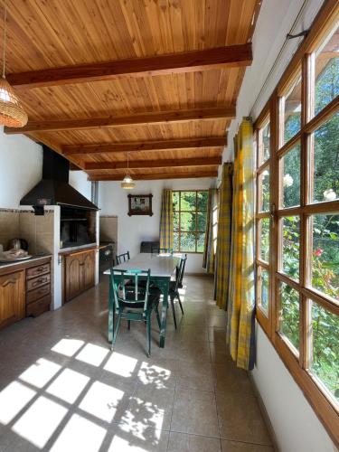ein Esszimmer mit einem Tisch und einigen Fenstern in der Unterkunft Casa para descansar in San Carlos de Bariloche
