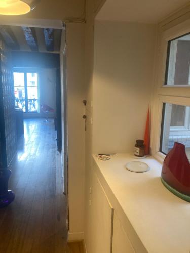 une pièce avec un comptoir et une fenêtre et un couloir dans l'établissement Appartement Saint-Paul Le Marais, à Paris