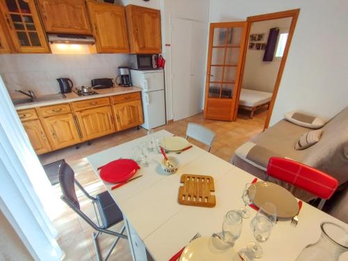 - une cuisine avec une table et des chaises blanches dans la chambre dans l'établissement Charmant T2, quartier résidentiel calme, St Aygulf, à Fréjus