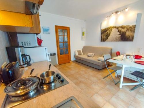 Il comprend une cuisine et un salon avec une cuisinière. dans l'établissement Charmant T2, quartier résidentiel calme, St Aygulf, à Fréjus