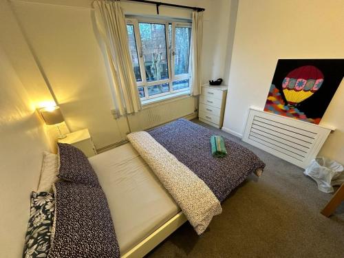 a small bedroom with a bed and a window at Victoria Park R4 in London