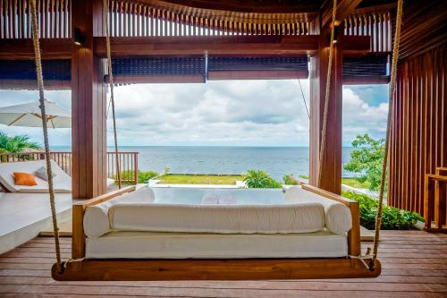 a swinging bed in a room with a view of the ocean at The Angsa villas in Amed