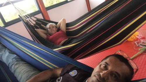 een man en een vrouw in een hangmat bij Casa La Aurora Posada in Restrepo