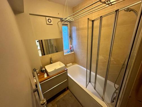 La salle de bains est pourvue d'une baignoire, d'un lavabo et d'une douche. dans l'établissement Victoria Park R4, à Londres