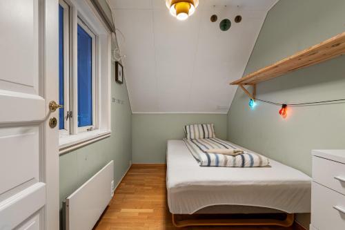 Habitación pequeña con cama y ventana en Villa Arctica, en Tromsø