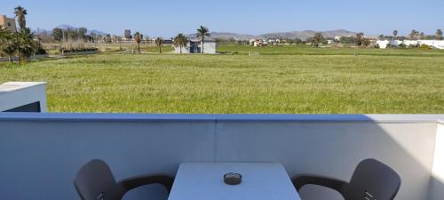 a table and chairs with a view of a field at VENOS APARTMENTS in Marmari
