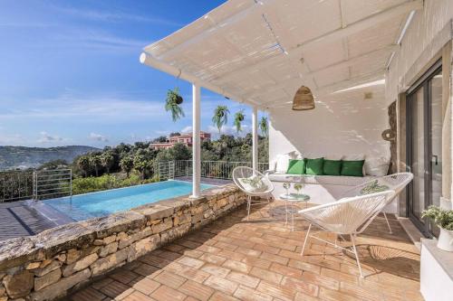 a patio with chairs and a swimming pool at Casa do Tempo in Faro