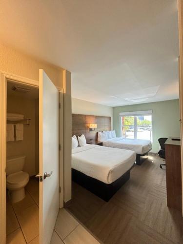a hotel room with two beds and a bathroom at Baymont by Wyndham Lake Park Valdosta I75 in Lake Park