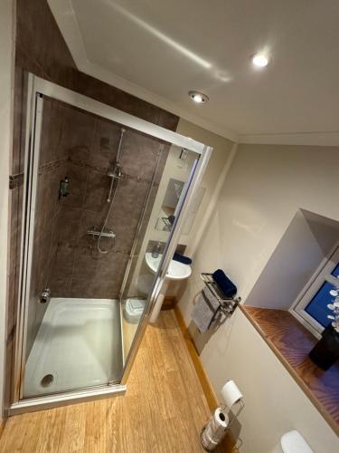 a bathroom with a shower and a toilet at Town Centre 2 bedroom apartment in Wick