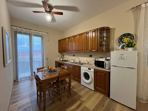 een keuken met een tafel en een witte koelkast bij HIMERA LOFT - Holiday Home and Apartment in Termini Imerese