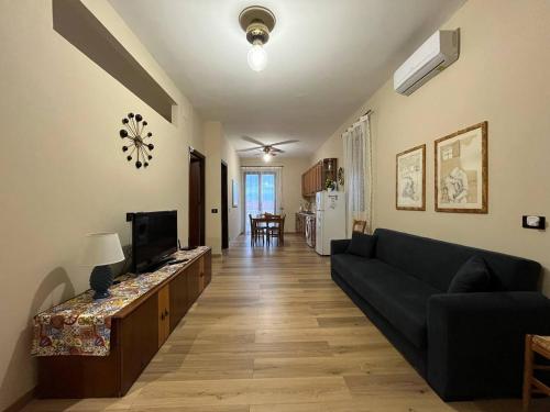 een woonkamer met een bank en een televisie bij HIMERA LOFT - Holiday Home and Apartment in Termini Imerese