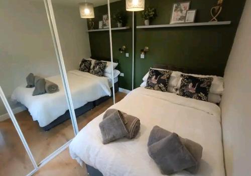 a room with two beds and a mirror at The Annex, Stratford Upon-Avon in Stratford-upon-Avon