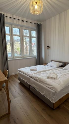 a bedroom with a large bed and a chandelier at CityCenterApartments/M32/6 in Bielsko-Biała