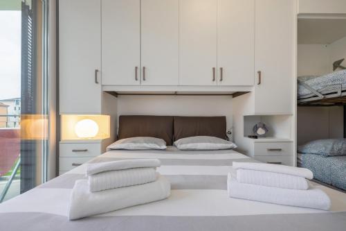 een slaapkamer met een groot wit bed en witte kasten bij La Casa Nuova - Pietra Ligure in Pietra Ligure