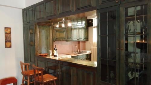 a kitchen with wooden cabinets and a counter top at Nostos-Δωρεάν κλειστός χώρος στάθμευσης in Volos