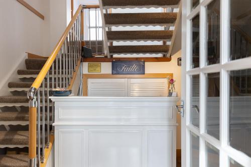 a hallway with a white door and stairs at Stornoway Bed and Breakfast in Stornoway
