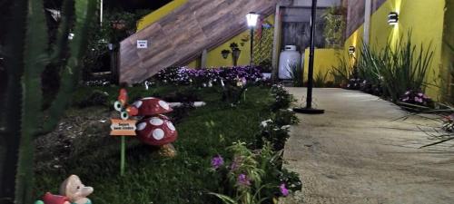a garden with flowers in the grass next to a building at Hospedagem Encantos da Serra in Itatiaia