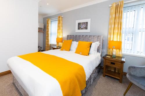 a bedroom with a large bed with yellow pillows at Stornoway Bed and Breakfast in Stornoway