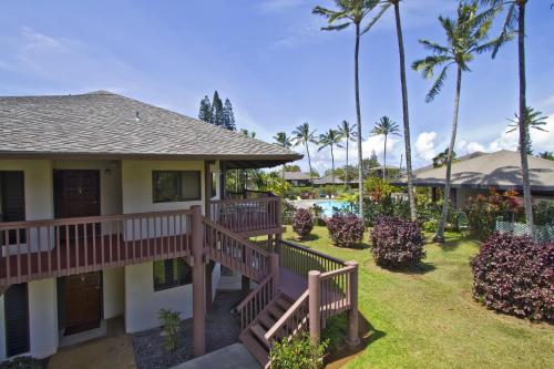 a house with a deck and a yard with a pool at Club Wyndham Ka Eo Kai in Princeville