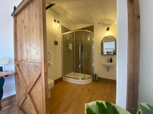 a bathroom with a shower and a glass door at Entire Glamping Site inc Dinner, Bed & Breakfast for 10 in East Chinnock