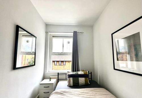 a small bedroom with a bed and a window at Whitechapel Station Rooms in London