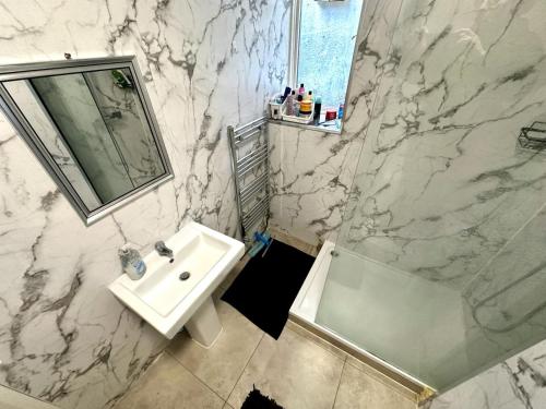 a white bathroom with a sink and a shower at Whitechapel Station Rooms R1 in London