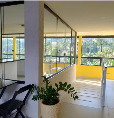 a room with a chair and a potted plant at Hospedagem Encantos da Serra in Itatiaia