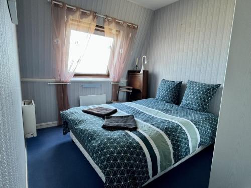 - une chambre avec un lit et une fenêtre avec des serviettes dans l'établissement Duplex vue sur mer, à Cabourg