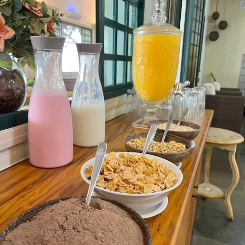 een tafel met kommen met eten en flessen melk bij SR Boutique Hotel in São Pedro