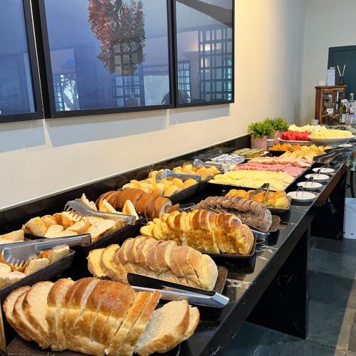 een buffet gevuld met veel verschillende soorten brood bij SR Boutique Hotel in São Pedro