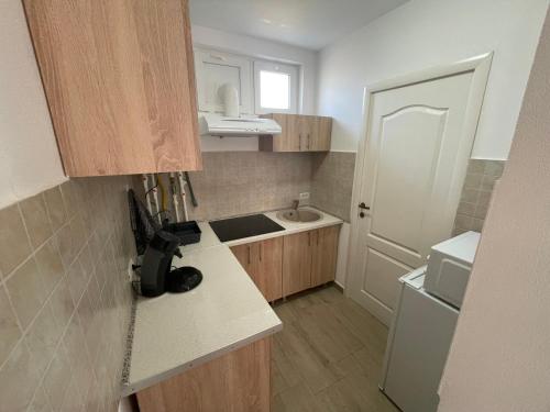 a small kitchen with a sink and a white door at R.M Apartament in Lugoj