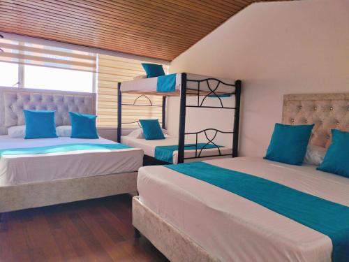 2 camas en una habitación de color azul y blanco en Hotel Batan 127, en Bogotá