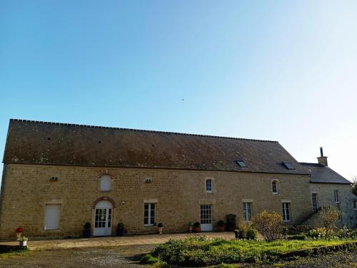 ein großes Backsteingebäude mit einem Dach in der Unterkunft Chambres au Manoir 3 au 8 juin ! in Subles