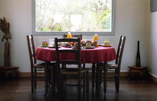 a dining room table with a red table cloth at Chambres d'Hôtes La mésange à tête Bleue in Pierre-de-Bresse