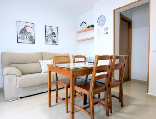 sala de estar con mesa, sillas y sofá en Apart ConiL10, en Conil de la Frontera