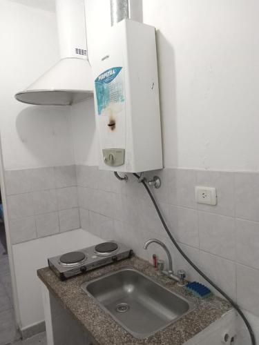 uma cozinha com um lavatório e uma luz por cima em Depto Dm II centro em San Fernando del Valle de Catamarca