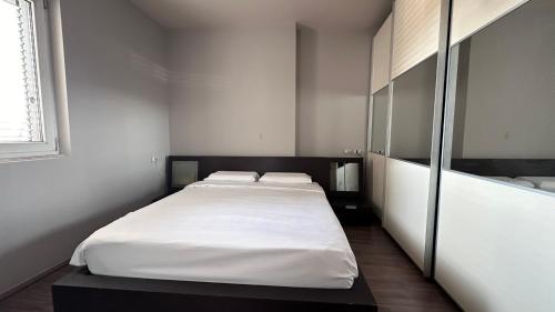 a bedroom with a large white bed in it at CozyNest Apartments in Tirana
