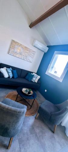 un salon avec un canapé et deux chaises dans l'établissement L'Ophelia Duplex Dernier étage balcon Centre climatisation, à Sète