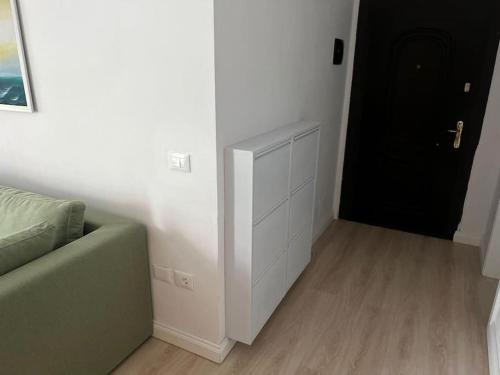 a living room with a green couch and a black door at Green Apartment Durrës in Durrës