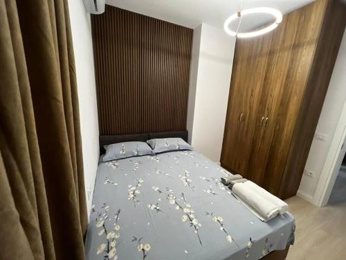 a bedroom with a bed with a blue comforter with flowers at Green Apartment Durrës in Durrës