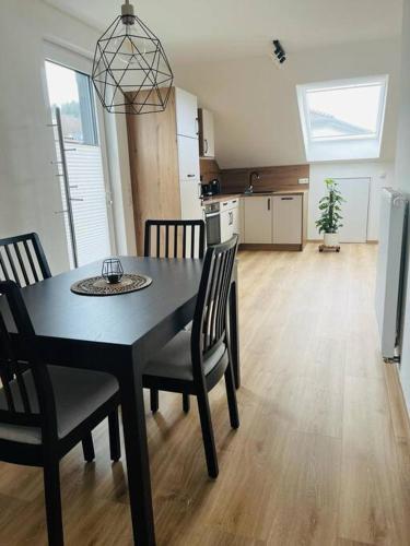 a kitchen and dining room with a black table and chairs at Bei Freddy in Prüm