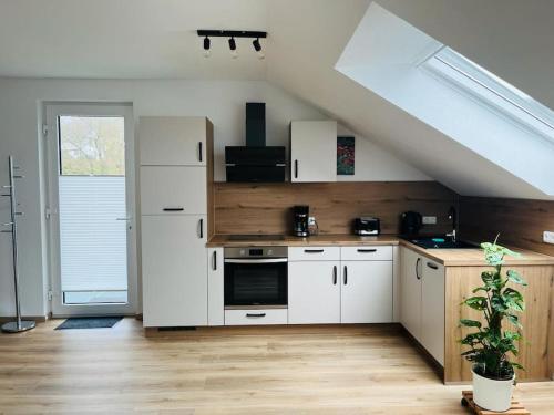 a kitchen with white cabinets and a staircase at Bei Freddy in Prüm