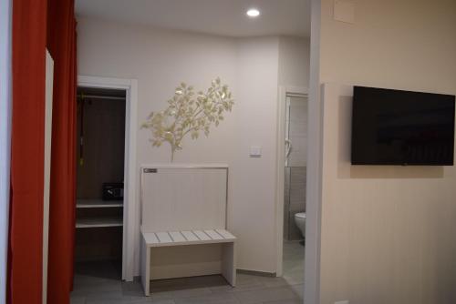 a bathroom with a toilet and a tv on a wall at Hotel Lido in Varazze