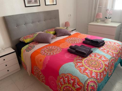 ein Schlafzimmer mit einem großen Bett mit einer farbenfrohen Tagesdecke in der Unterkunft Apartament La Mata in Torrevieja
