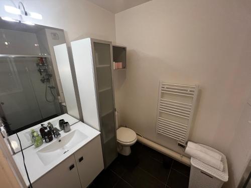 une salle de bain avec un lavabo, des toilettes et une douche dans l'établissement Élysée Lumière Résidence Prestige Paris-La Défense, à Colombes